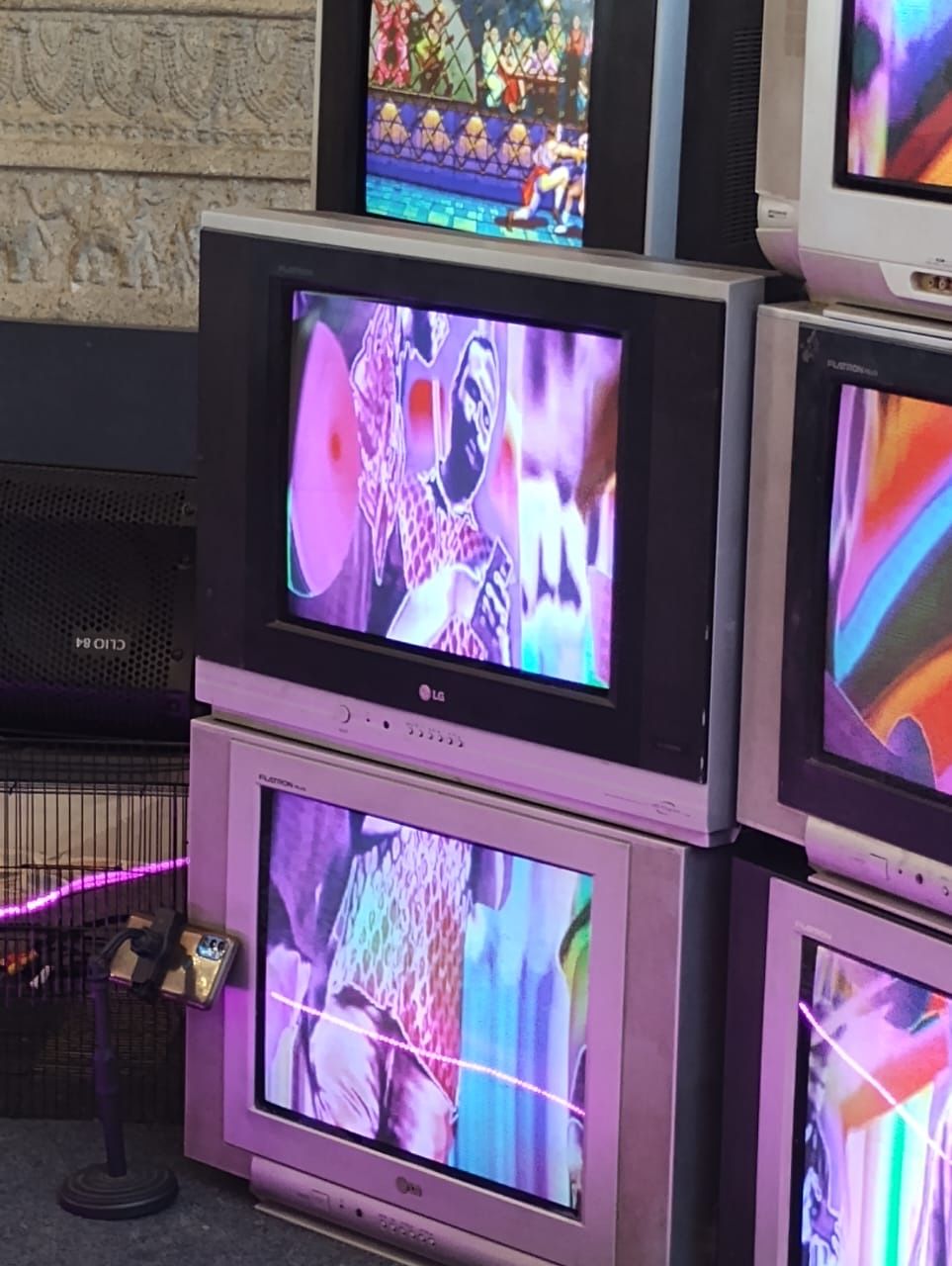 A distorted live image of a visitor appears across the CRT screens.