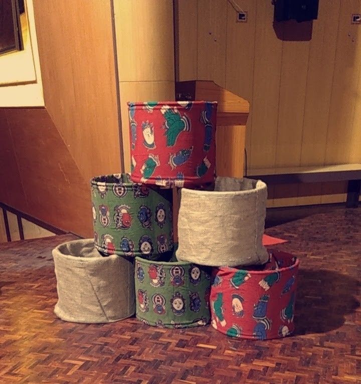 Stacked cylindrical forms made from linen and brightly illustrated fabric.