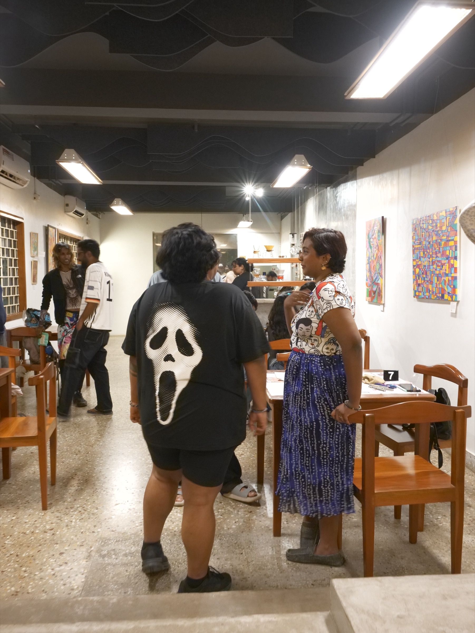 Visitors talk among the paintings during the Human Music exhibition opening.