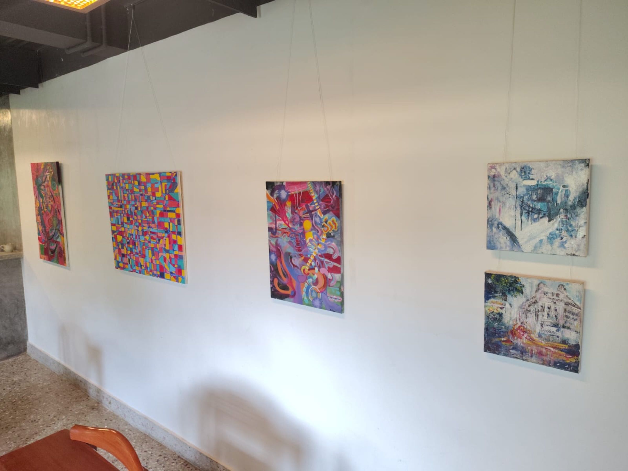 Five Human Music paintings installed in a row along a white wall at Vinyl & Brew.