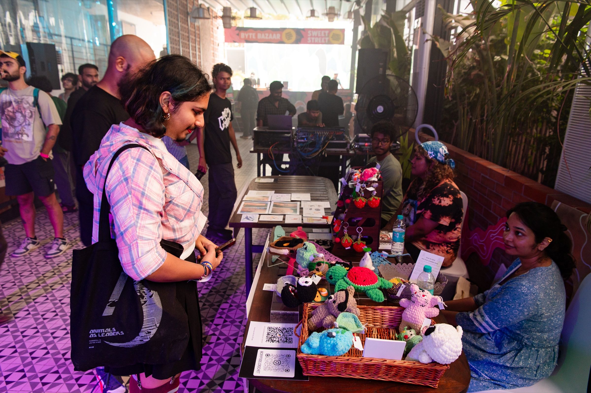 A visitor browses crocheted creatures and art prints at the busy Angular Festival makers market.