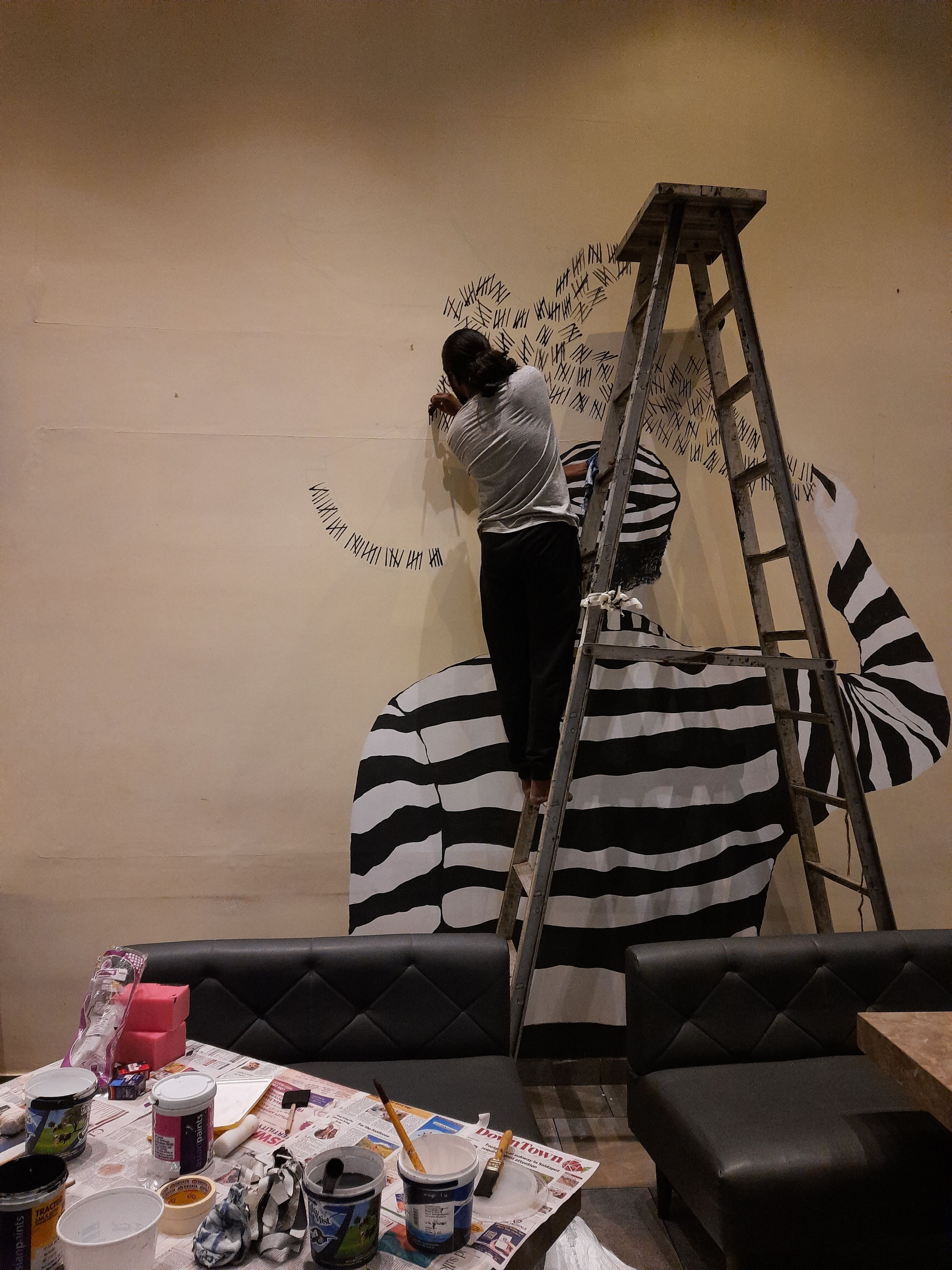 Artists painting the large-scale Kaidi Kitchen murals on site.